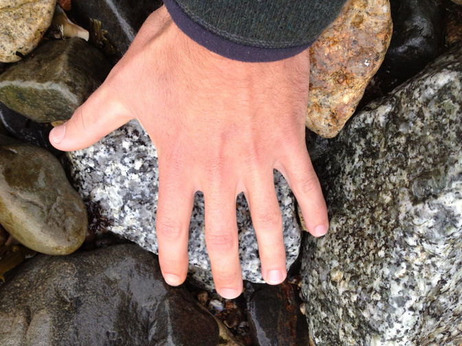 Brian's hand adjusting a rock. Water feature project by O'Connor Stone & Landscape