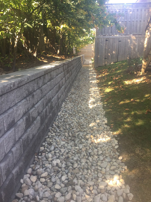 Engineered retaining wall with dry river bed. A retaining wall project by O'Connor Stone & Landscape